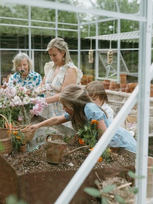 Rachel Wavra gardening with family, cutting fresh flowers in the greenhouse